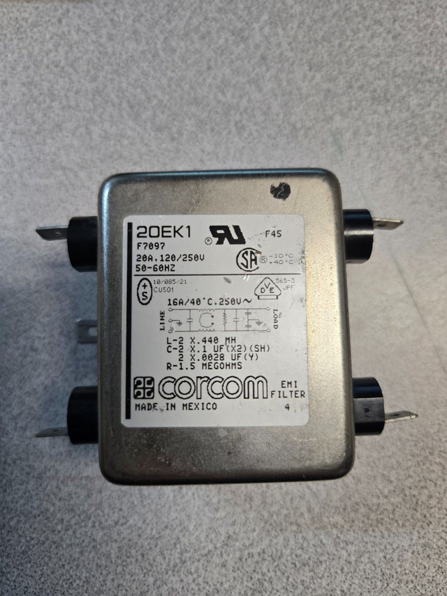 The label on a Corcom 20EK1 EMI filter, reading 20 amps at 120 or 250 volts, 50 to 60 hertz, with a separate line reading 16 amps at 40 degrees C, 250 volts AC. Below it a schematic of the filter and the component values: two 0.440 millihenry inductors, two 0.1 microfarad X capacitors, two 0.0028 microfarad Y capacitors and a 1.5 megohm bleeder resistor.